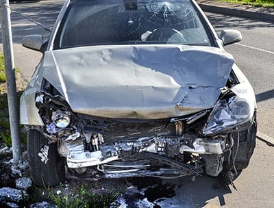 The front of a badly-damaged car which has been wrecked in a serious accident.