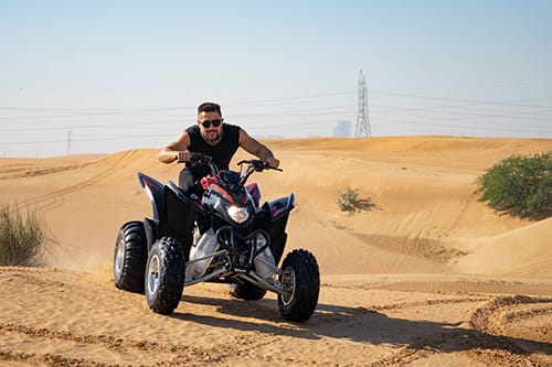man on a sports atv in sand dunes